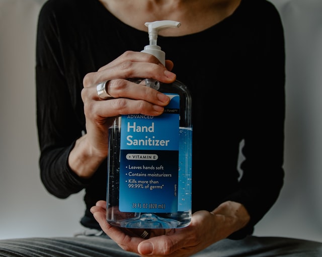 hands holding bottle of hand sanitizer